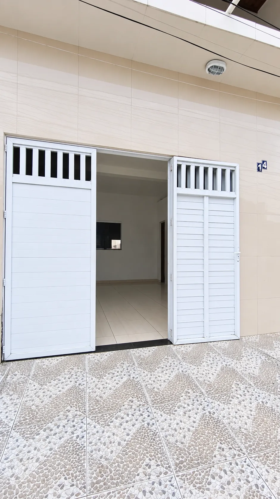 Entrada da casa, com porta de vidro e escada para o pavimento superior